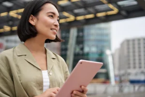 A woman using a tablet on the street.