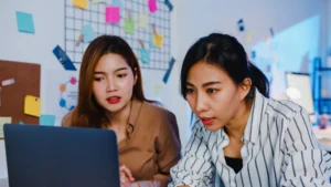 Two women working together on a laptop.